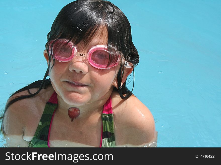 Girl popping out of water wearing pink goggles. Girl popping out of water wearing pink goggles.