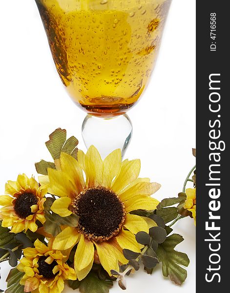 Big yellow wineglass with bouquet of artificial sunflower isolated with white background. Big yellow wineglass with bouquet of artificial sunflower isolated with white background