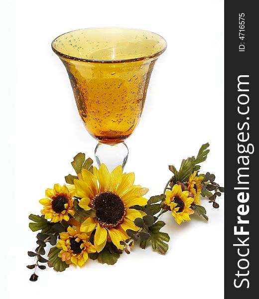 Big yellow wineglass with bouquet of artificial sunflower isolated with white background. Big yellow wineglass with bouquet of artificial sunflower isolated with white background