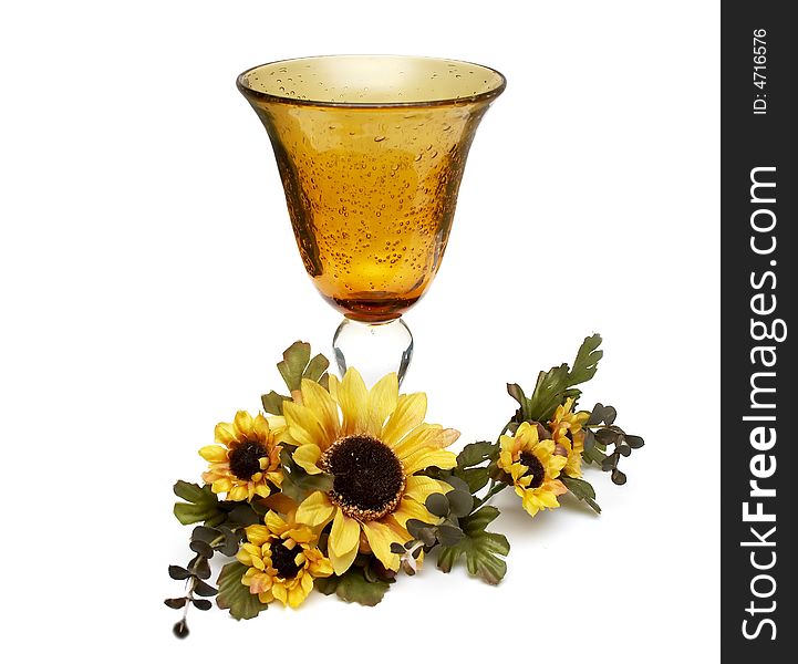 Big yellow wineglass with artificial sunflowers