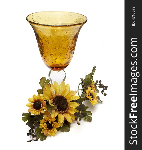 Big yellow wineglass with artificial sunflowers