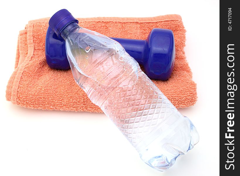 Water bottle and a blue dumbbell over a towel in a white surface. Water bottle and a blue dumbbell over a towel in a white surface