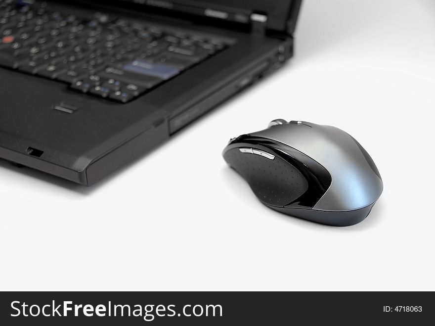 Modern black notebook computer on white background with computer mouse