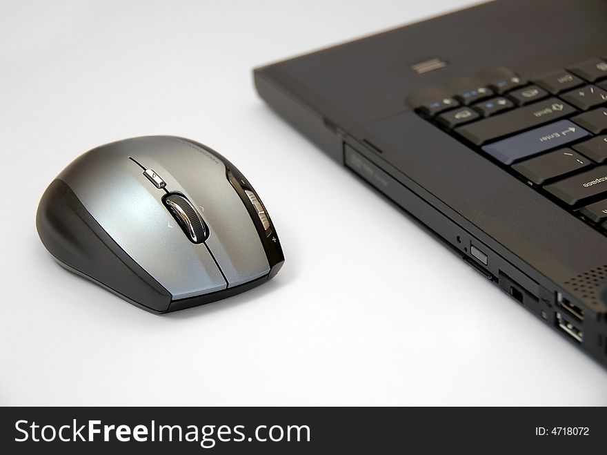 Modern black notebook computer on white background with computer mouse