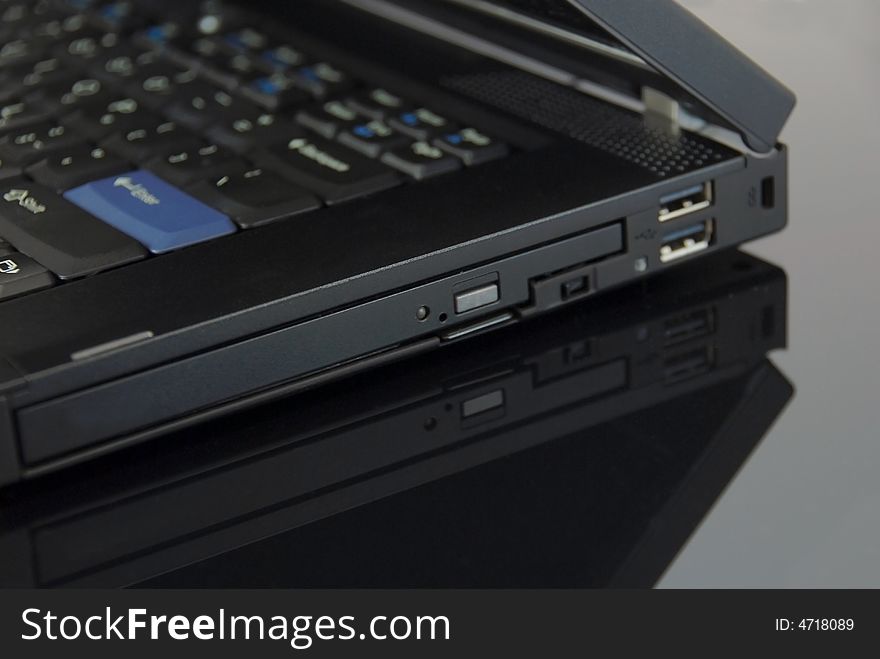 Modern black notebook computer on glass background