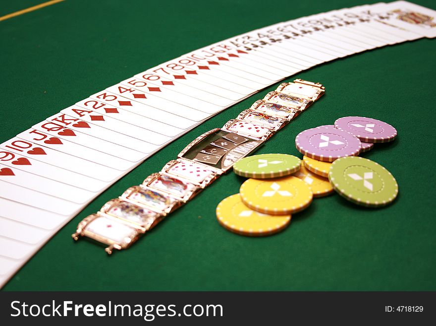 Cards, gold bracelet and chips on a table. Cards, gold bracelet and chips on a table
