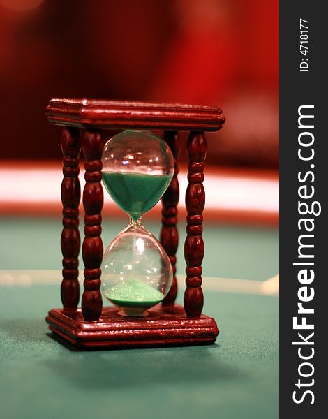 Sand-glass on a green poker table