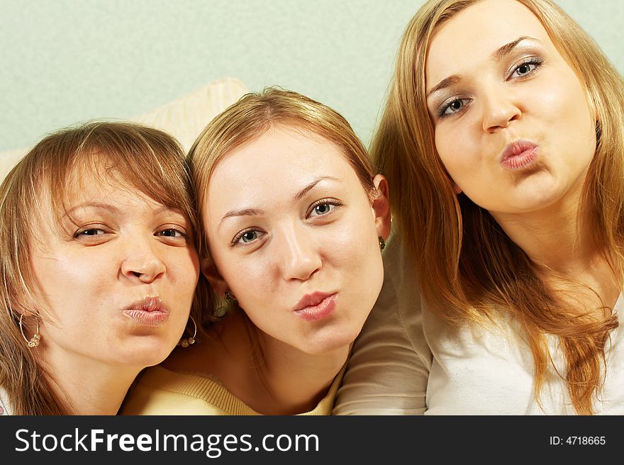 Three charming girls send an air kiss to the camera. Three charming girls send an air kiss to the camera