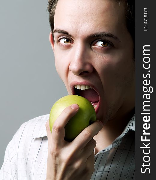 Young man eating a green apple. Young man eating a green apple