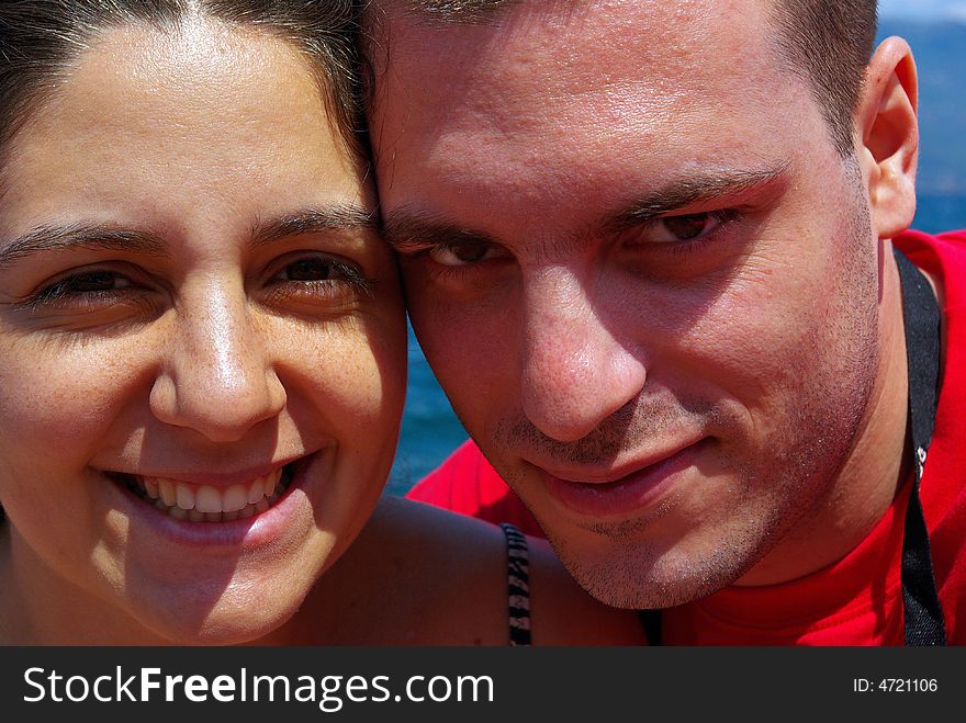 A couple, smiling, posing by a seaside. A couple, smiling, posing by a seaside