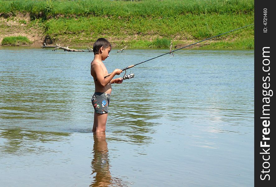 Boy fishing with spinning on the river
