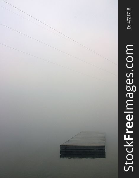 A dock is shrouded by an early morning fog. A dock is shrouded by an early morning fog.