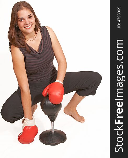 Healthy young woman in red boxing gloves sitting with glove covered hands and smiling her guard up at a boxing workout. Healthy young woman in red boxing gloves sitting with glove covered hands and smiling her guard up at a boxing workout.