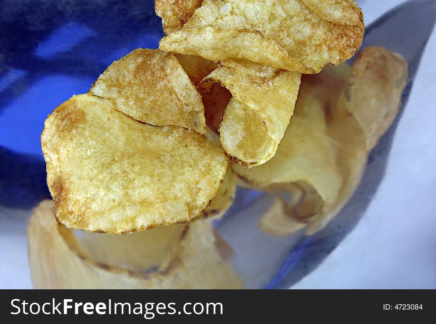 Potato chips close up on a stainless steel dish. Potato chips close up on a stainless steel dish.