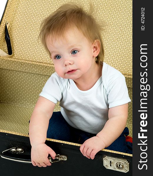 Small child sitting in a suitcase isolated on white. Small child sitting in a suitcase isolated on white