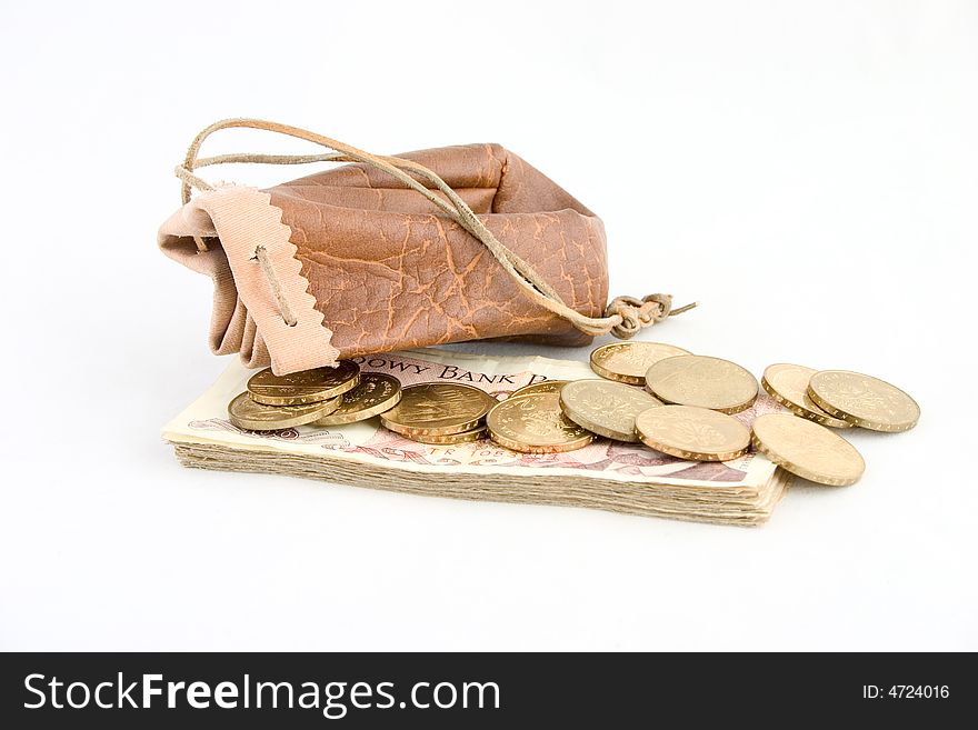 A brown leather pouch with gold coins and wad of banknotes isolated on white background. A brown leather pouch with gold coins and wad of banknotes isolated on white background.