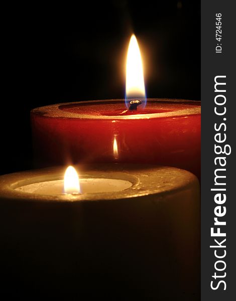 Two candles burning against a dark background.