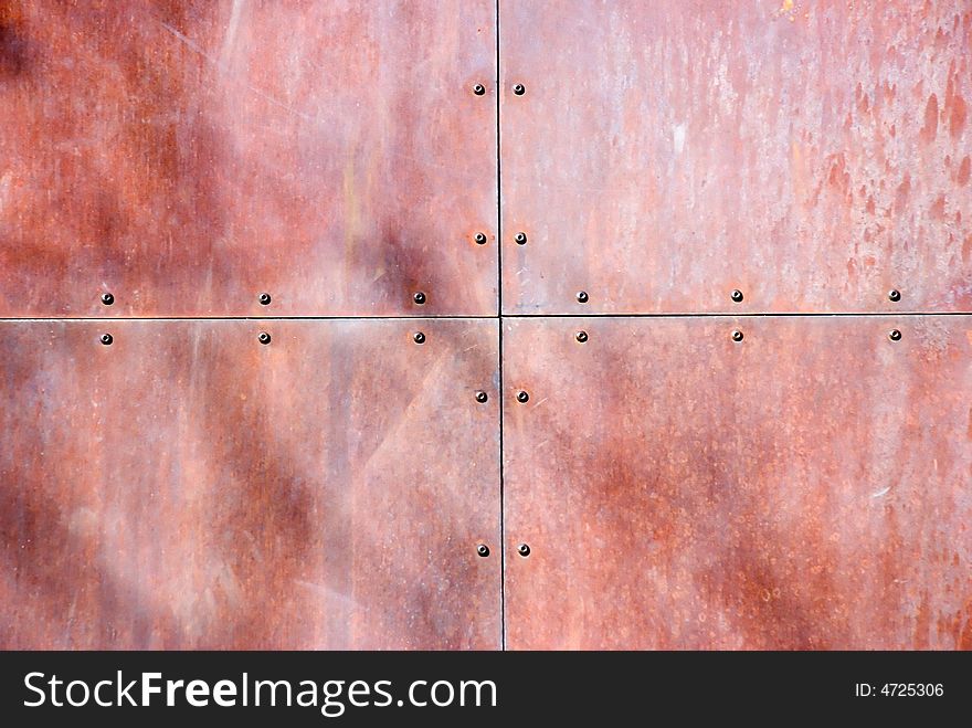 A riveted, rusted piece of sheet metal. A riveted, rusted piece of sheet metal