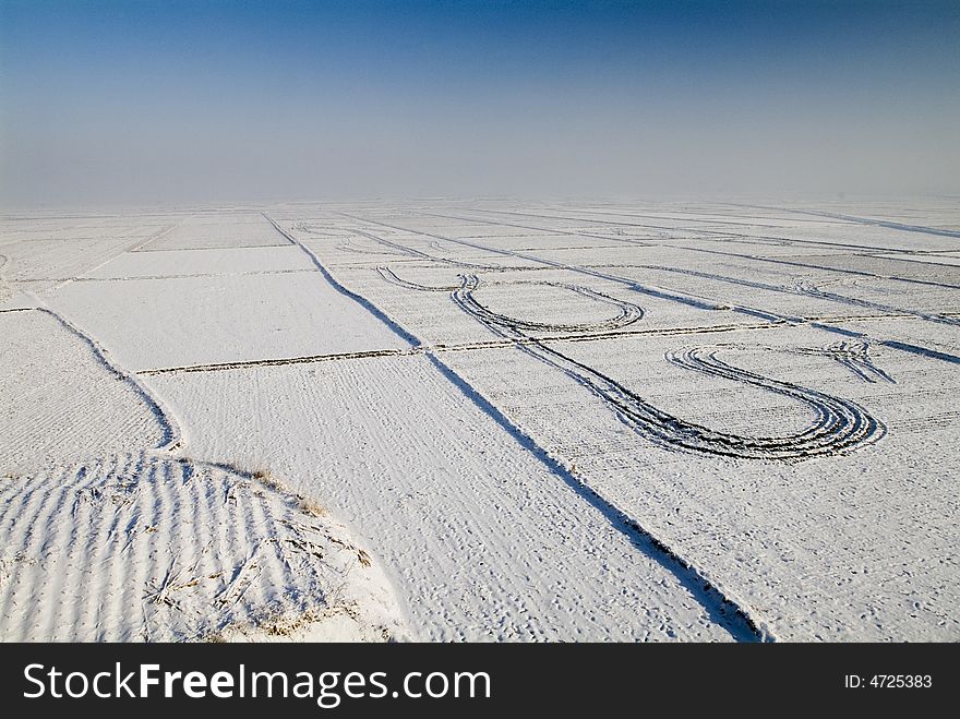 The plantation is covered with snow,and the air is blocked with heavy fog. 
The print of tractors wheel is clear. The plantation is covered with snow,and the air is blocked with heavy fog. 
The print of tractors wheel is clear.