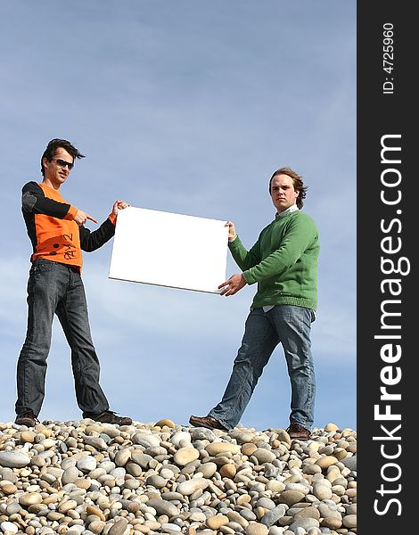 Two Young Men Holding White Card at the beach