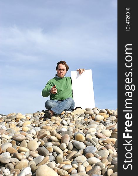 Young Man Holding White Card at the beach