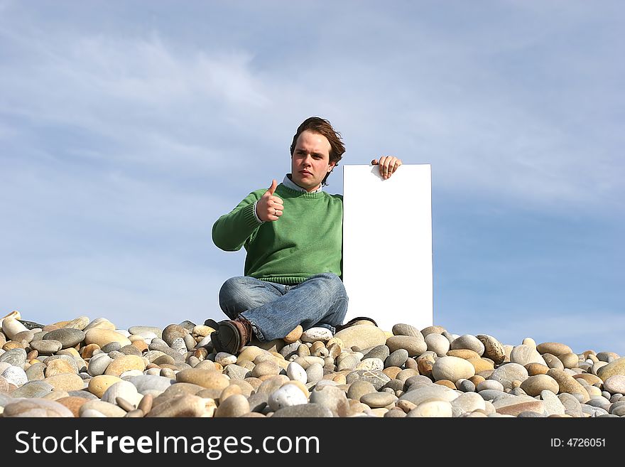 Young Man Holding White Card at the beach
