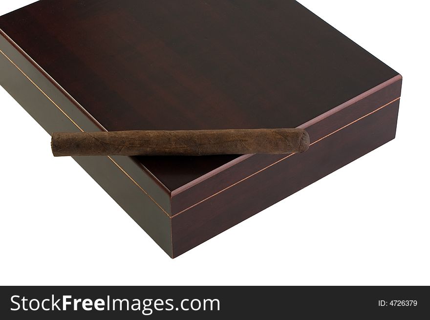A deep brown Maduro cigar rests atop a dark cherry-wood humidor, with clipping path. A deep brown Maduro cigar rests atop a dark cherry-wood humidor, with clipping path