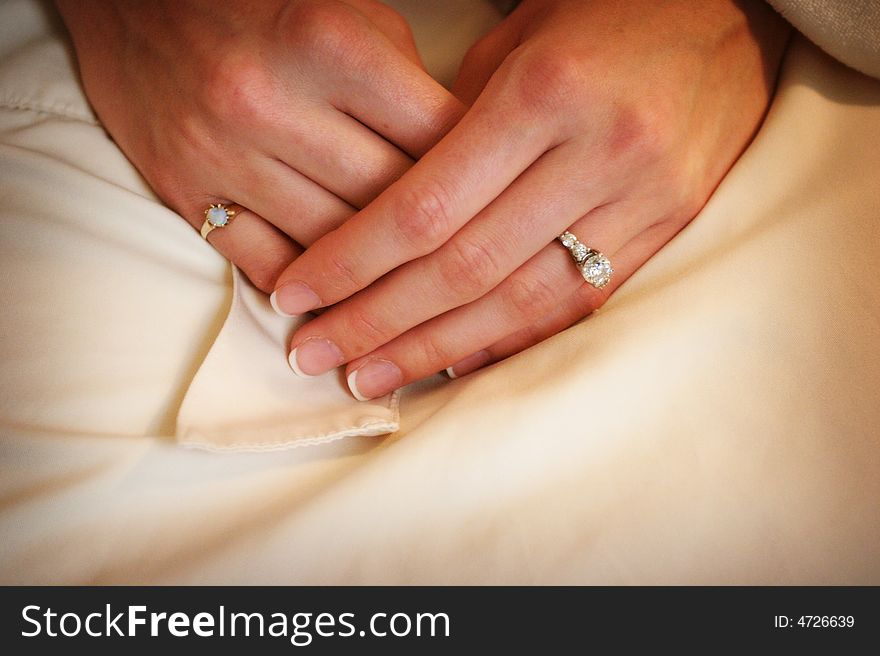 Wedding day Brides hands in her lap