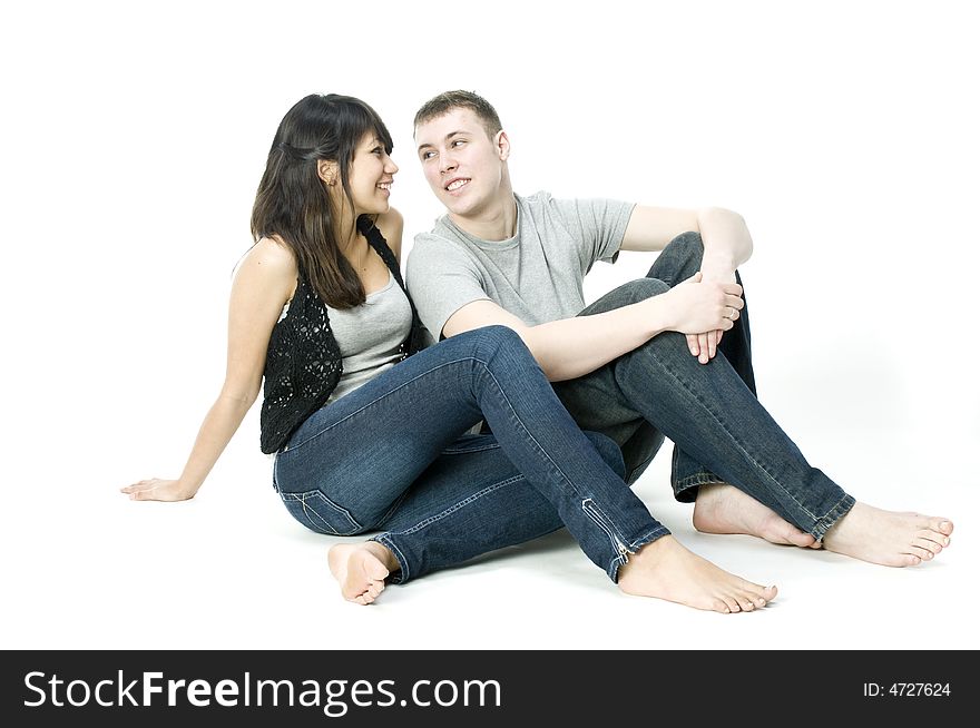 A young couple sitting with each other in a studio. A young couple sitting with each other in a studio