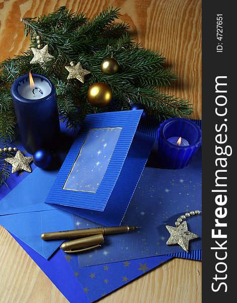 Slill-life with candle and holiday card in tones of gold and blue. Slill-life with candle and holiday card in tones of gold and blue.