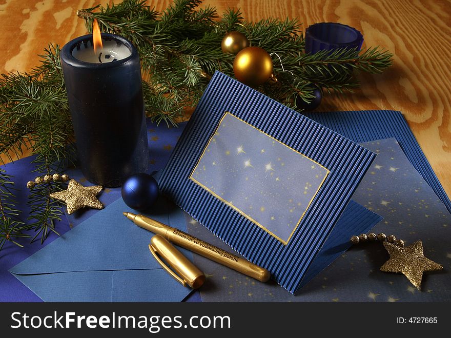 Slill-life with candle and holiday card in tones of gold and blue. Slill-life with candle and holiday card in tones of gold and blue.