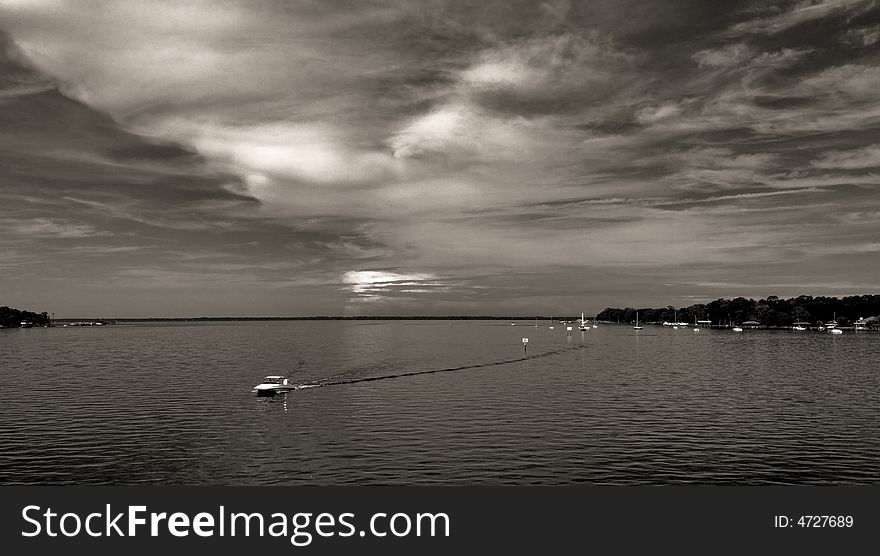 Water And Boat With Dramatic Sky And Clouds