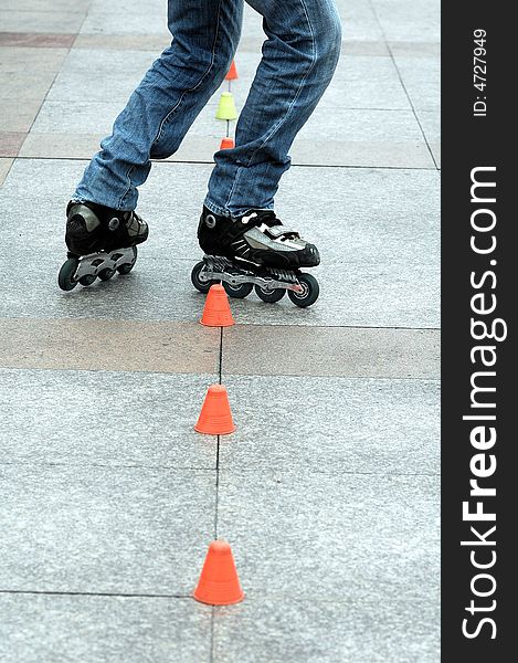 A man practice roller skating in the park.