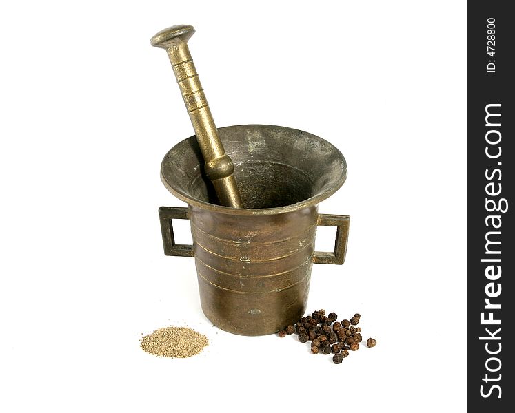 Mortar and pestle crushing pepper, with pepper spread around