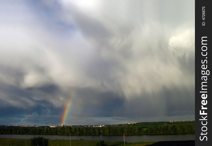 Storm clouds landscape with rainbow