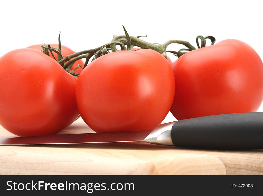 Fresh picked red vine tomatoes and knife white background. Fresh picked red vine tomatoes and knife white background