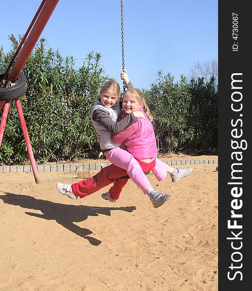 Twin sisters together on seesaw -a console with chain