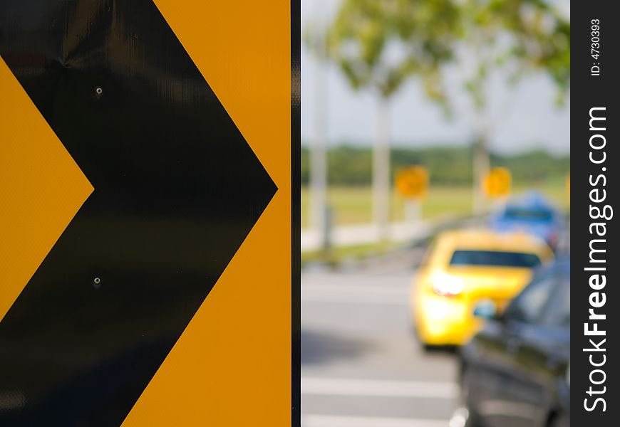 Chevron indicating a bend in a road with moving cars. Chevron indicating a bend in a road with moving cars