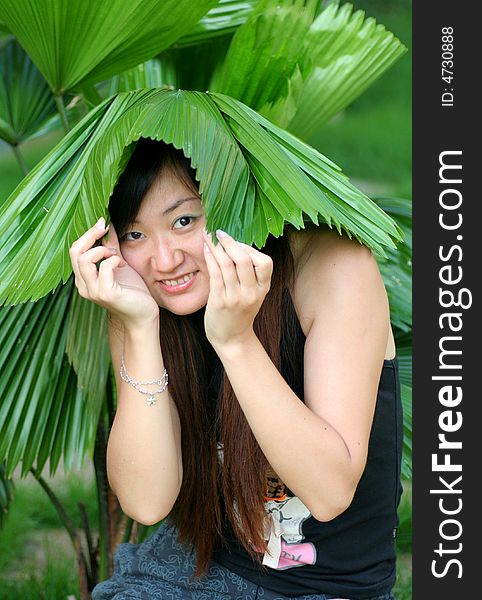 A happy young girl with green leaf