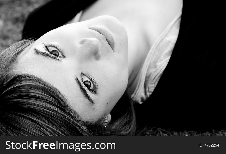 Laying woman staring at camera, black and white.