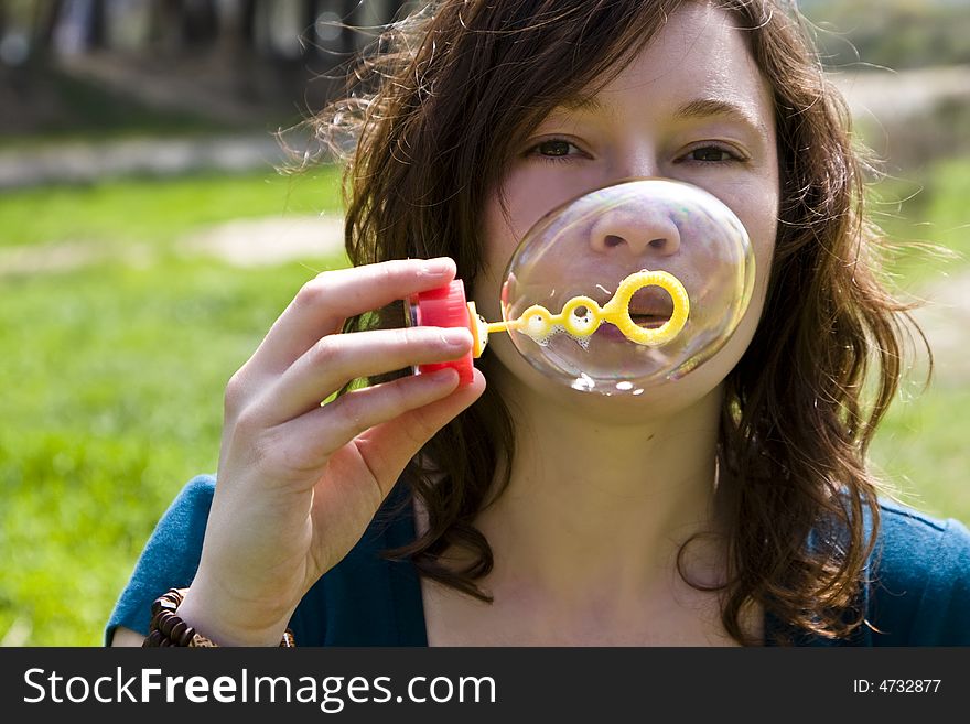 Red haired woman playing with soap bubbles