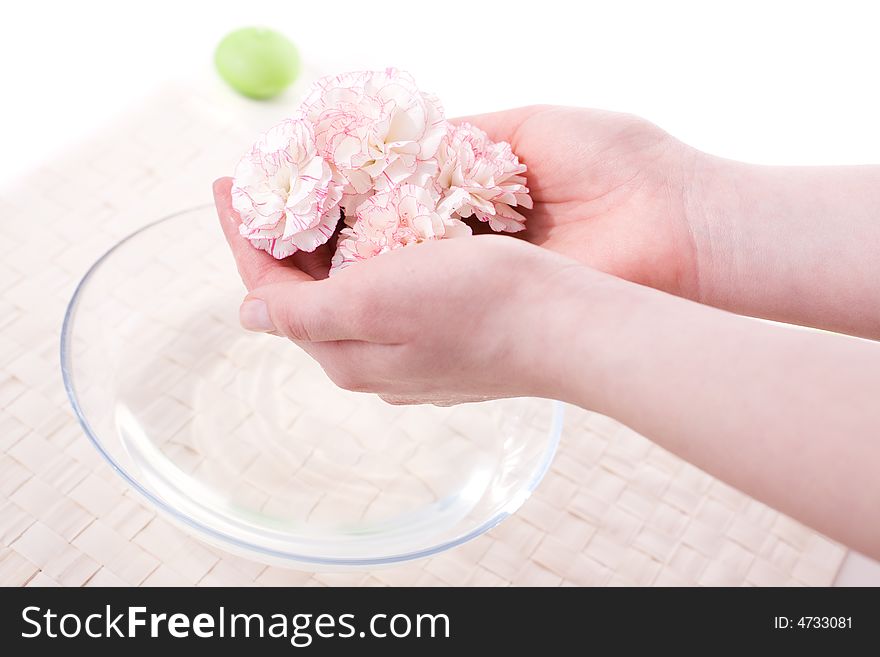 Female hands in bowl full of water and flower