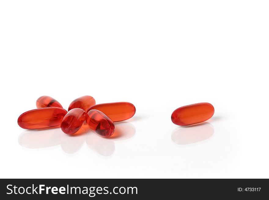 Translucent orange capsules on white background. Translucent orange capsules on white background