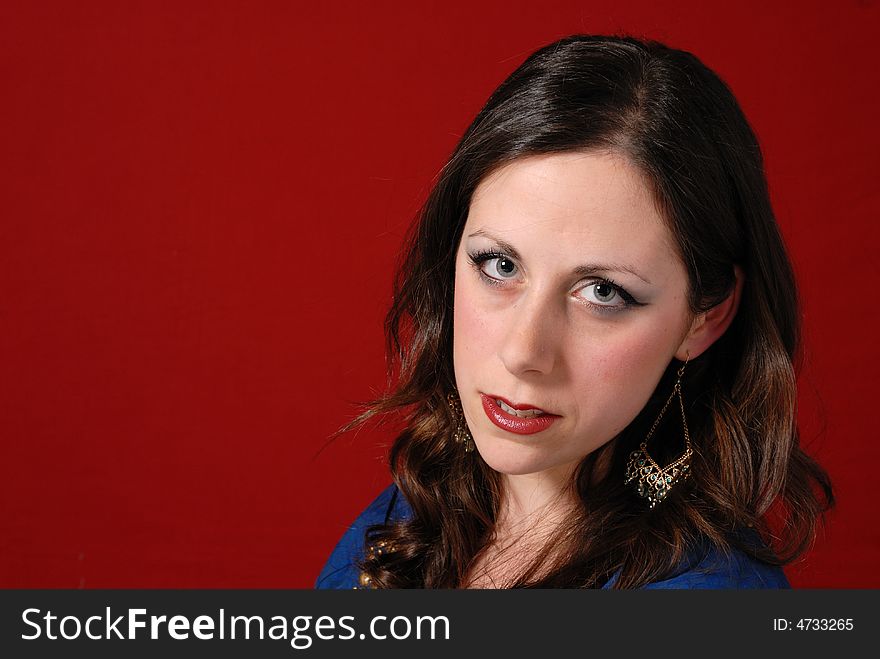 Portrait of attractive young lady in blue dress on red background