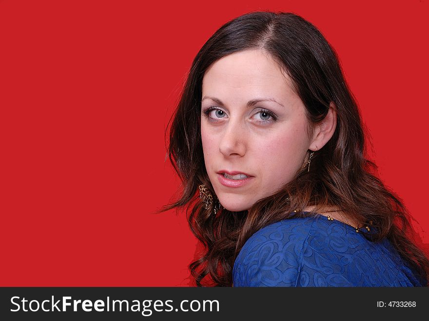 Portrait of attractive young lady in blue dress on red background