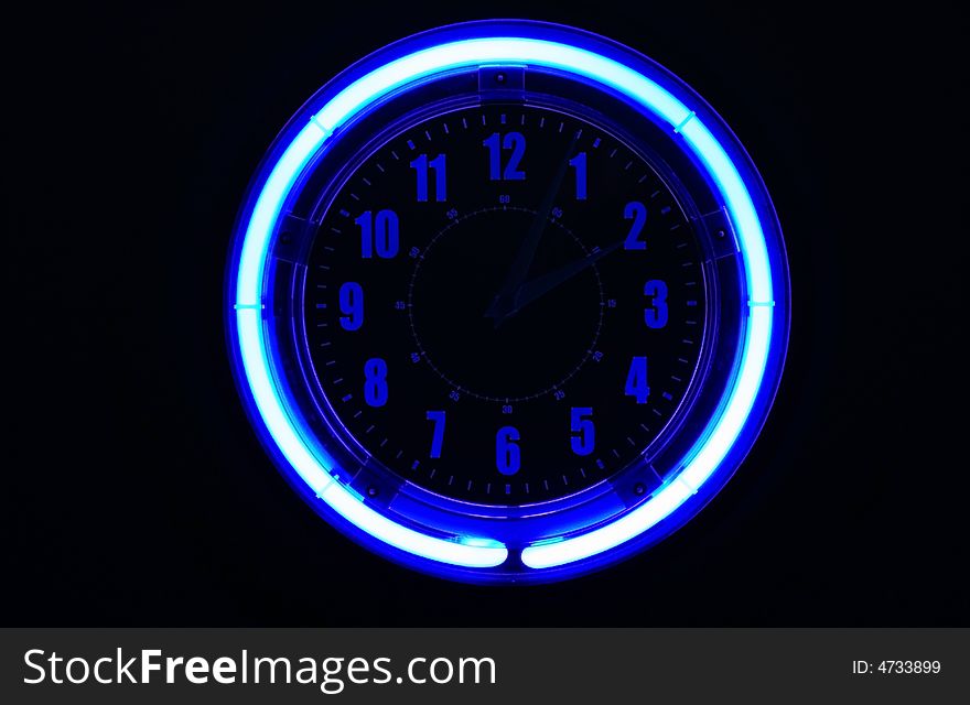 A bright blue clock glowing against a black background, hands are barely visible.  Sometimes you don't really want to know the time. A bright blue clock glowing against a black background, hands are barely visible.  Sometimes you don't really want to know the time.