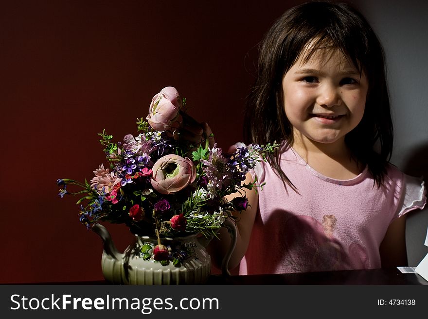 Little girl smiling standing next to a bunch of flowers. Little girl smiling standing next to a bunch of flowers