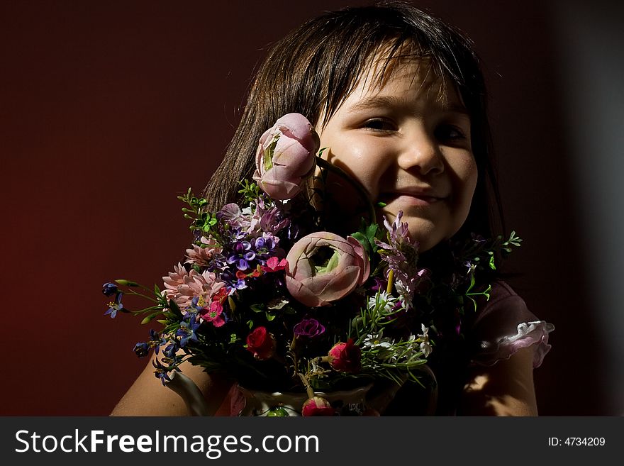 Little girl smiling hiding behind a bunch of flowers. Little girl smiling hiding behind a bunch of flowers