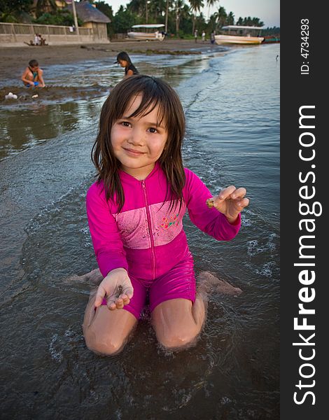 Girl finding shells on the beach at sunset
