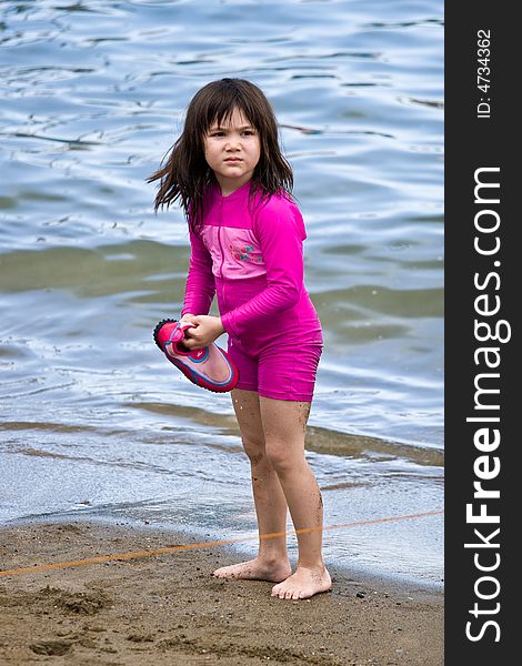 Girl walking on the sand on the beach looking for her shoe. Girl walking on the sand on the beach looking for her shoe